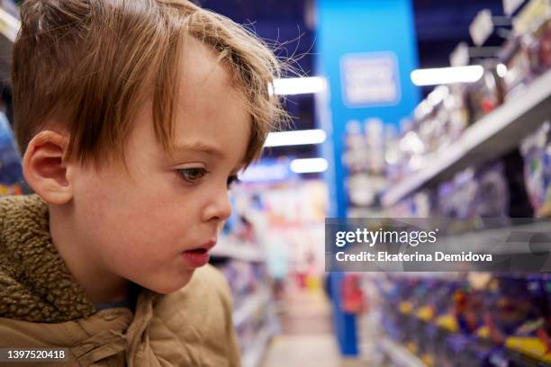 boy in a toy store close-up - leksaksaffär bildbanksfoton och bilder