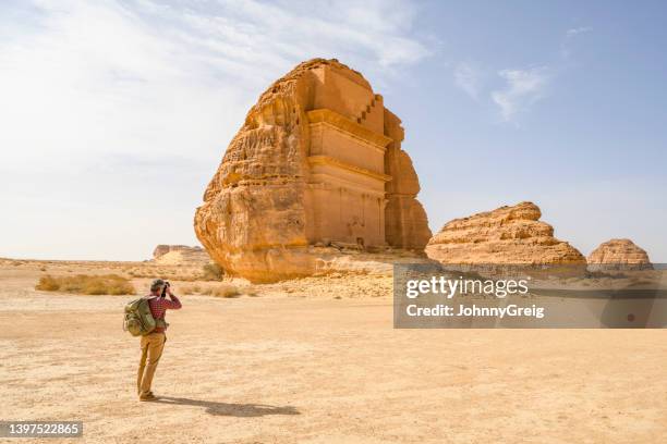 world travelling photographer taking pictures in hegra - mada'in saleh stockfoto's en -beelden
