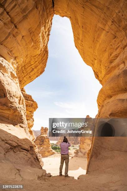 man photographing sandstone outcrops from jar rock, al-ula - al ula saudi arabia stockfoto's en -beelden