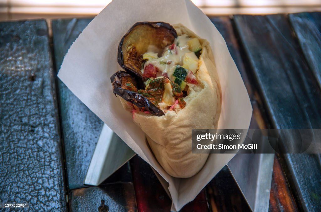 Vegetarian grilled eggplant, egg and salad pita bread sandwich with yogurt and tomato sauces at a take out food stall