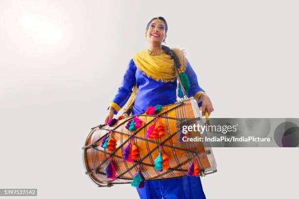 portrait of sikh woman playing drum during baisakhi celebration - baisakhi stock pictures, royalty-free photos & images