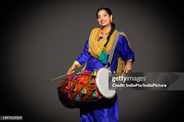 portrait of sikh woman playing drum during baisakhi celebration - baisakhi stock pictures, royalty-free photos & images