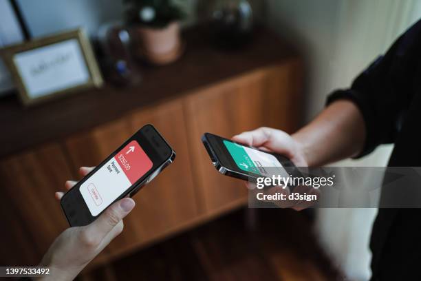 cropped shot of a man and a woman's hand holding smartphone, sending money through digital wallet, using online banking mobile app device. friends holding mobile phone to activate nfc. smart banking with technology - apple pay mobile payment stock-fotos und bilder