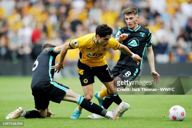 Pedro Neto of Wolverhampton Wanderers is challenged by Sam Byram and Billy Gilmour of Norwich City during the Premier League match between...