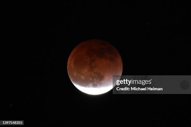 Total lunar eclipse creates a "super blood moon" on May 15, 2022 in Huntington Beach, California. The eclipse coincided with a super moon which...