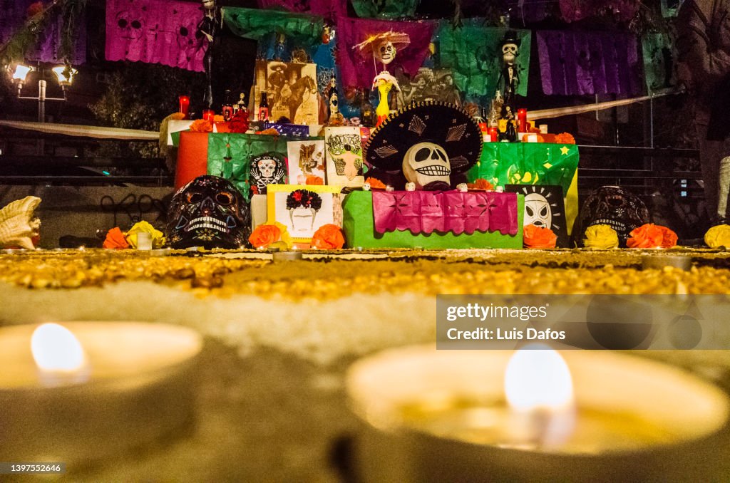 Candles circle a Day of the Dead altar.
