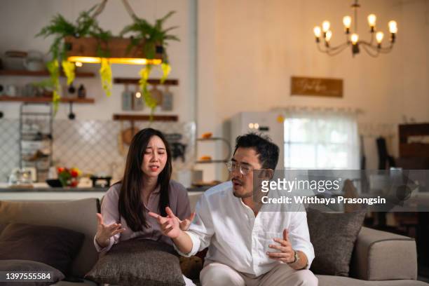 young couple having argument at home - asian couple arguing stock-fotos und bilder