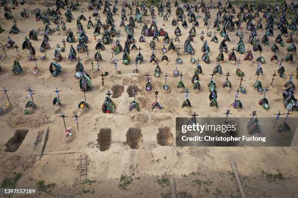 An aerial view of crosses, floral tributes and photographs of the victims of the battles for Irpin and Bucha that mark the graves in Irpin cemetery...