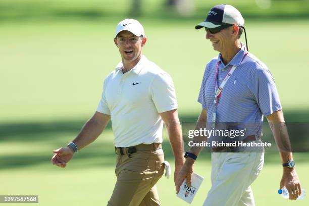 Rory McIlroy of Northern Ireland walks with Brad Faxon during a practice round prior to the start of the 2022 PGA Championship at Southern Hills...