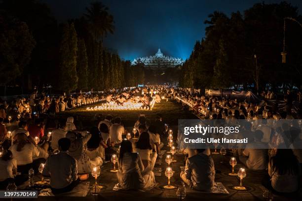 Buddhist devotees and tourists prepare to release lanterns into the air on Borobudur temple during celebrations for Vesak Day on May 16, 2022 in...