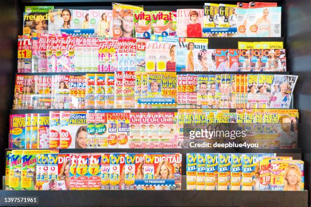 women's magazines and tv guide magazines on public newsstand shell - banca de jornais imagens e fotografias de stock