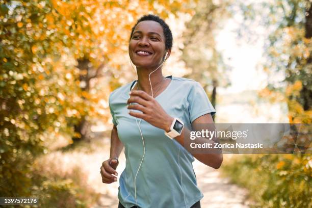corredora afroamericana practicando al aire libre - women running fotografías e imágenes de stock