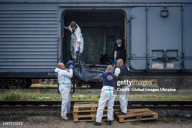 Ukrainian forensic experts unload from a refrigerator railway car the bodies of dead Russian soldiers, who died in settlements north of Kharkiv, to...