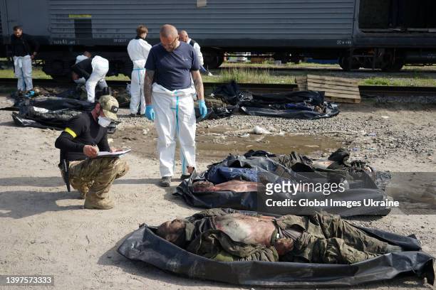Ukrainian forensic experts describe the bodies of dead Russian soldiers, who died in settlements north of Kharkiv, on May 14, 2022 in Kharkiv,...