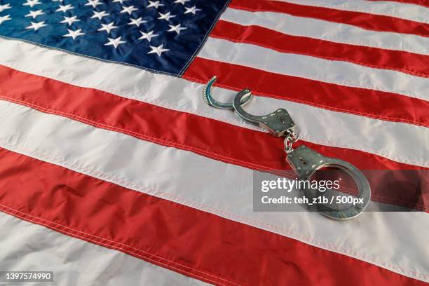 silver metal handcuffs over us flag on flat surface - 政府閉鎖 個照片及圖片檔