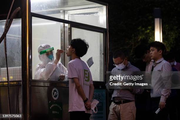 Health worker takes a swab sample from the resident to test for the Covid-19 coronavirus on May 16, 2022 in Wuhan, Hubei Province, China. According...