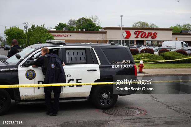 Police and FBI agents continue their investigation of the shooting at Tops Market on May 16, 2022 in Buffalo, New York. A gunman opened fire at the...