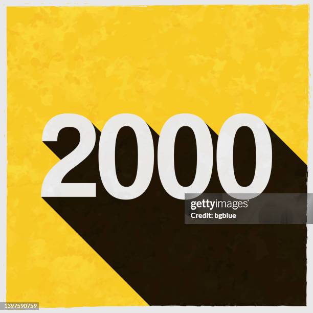 2000 - zweitausend. symbol mit langem schatten auf strukturiertem gelbem hintergrund - 2000 stock-grafiken, -clipart, -cartoons und -symbole