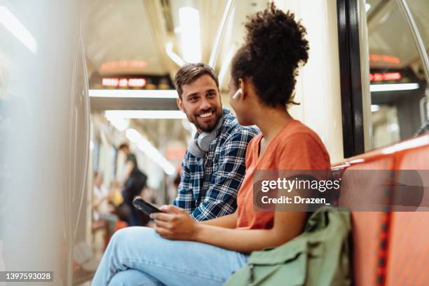 se déplacer en métro, les gens parlent pendant le trajet et sourient - individu étrange photos et images de collection