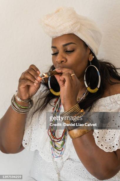 cuban santera lighting up a cigar - beautiful women smoking cigars 個照片及圖片檔