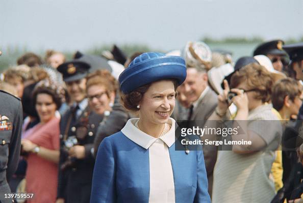 Queen Elizabeth II wearing a blue suit and hat during a visit to New ...