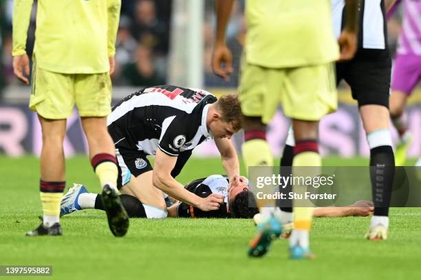 Emil Krafth of Newcastle United checks on Fabian Schaer of Newcastle United who lies injured during the Premier League match between Newcastle United...