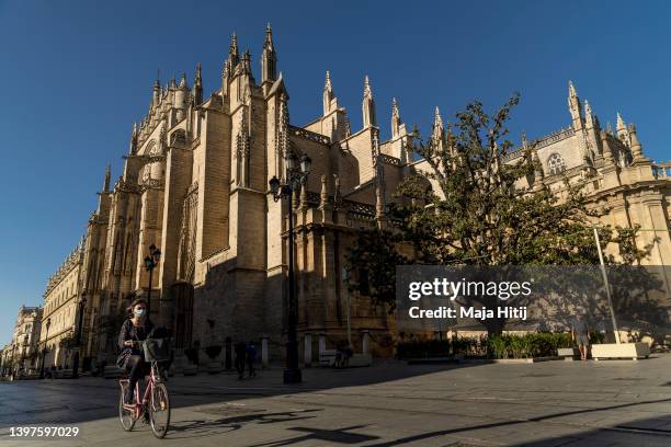 Woman rides a bike near to the Cathedral of Saint Mary of the See, better known as Seville Cathedral, on May 16, 2022 in Seville, Spain. Rangers FC...