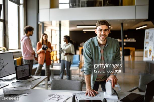 portrait of businessman in the office holding vr headset - headwear stockfoto's en -beelden