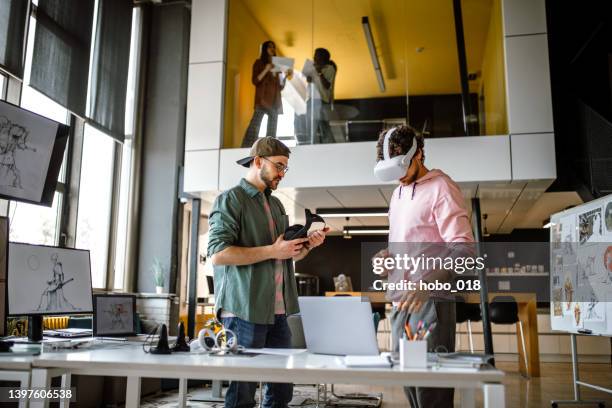 grupo de compañeros de trabajo probando simulador de realidad virtual en la oficina - interactividad fotografías e imágenes de stock