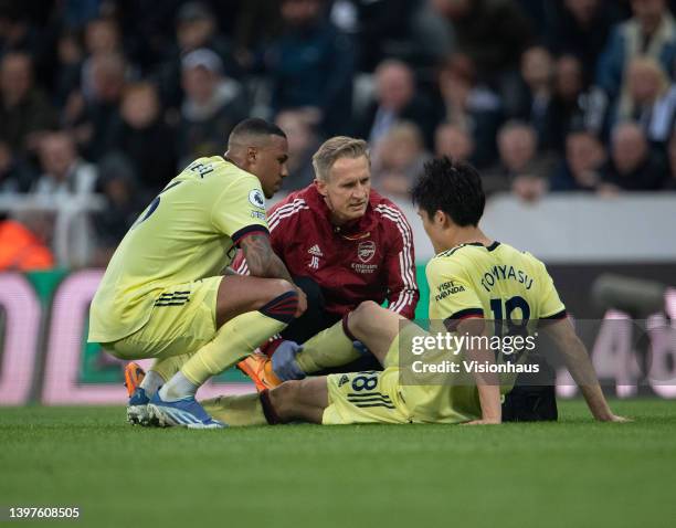 Takehiro Tomiyasu of Arsenal is treated for an injury with Gabriel of Arsenal during the Premier League match between Newcastle United and Arsenal at...