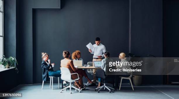 group of businesspeople having a meeting at their company - wide angle lens stock pictures, royalty-free photos & images