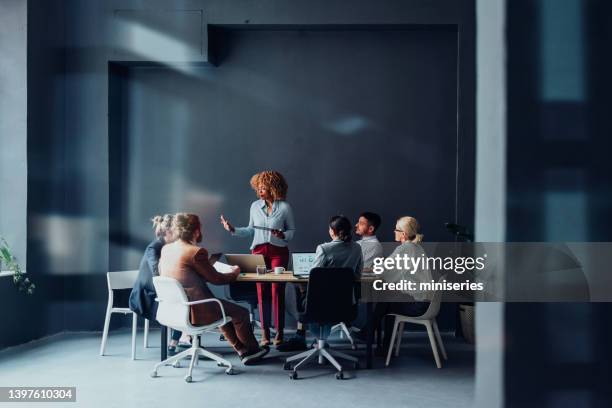 groupe d’hommes d’affaires ayant une réunion dans leur entreprise moderne - femme dans un groupe dhommes photos et images de collection