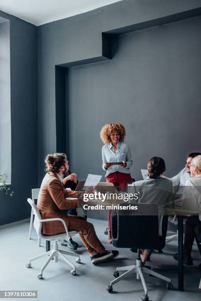 group of businesspeople on a meeting at their company - business vertical stock pictures, royalty-free photos & images