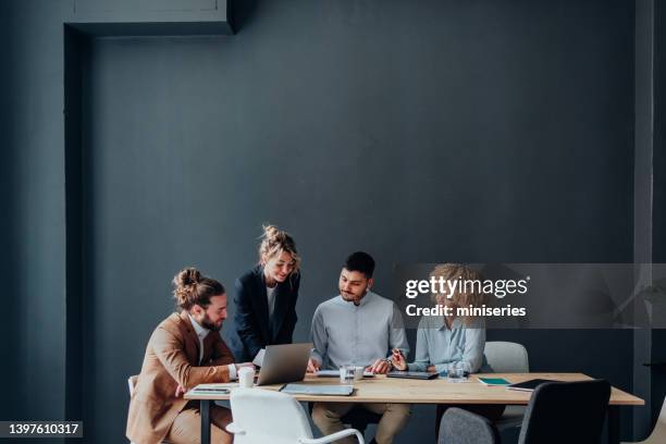 group of happy businesspeople working together at their company - four people and meeting stock pictures, royalty-free photos & images