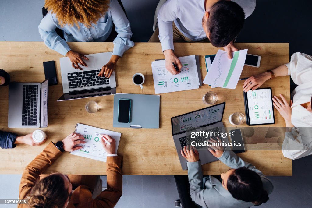 Group of Businesspeople Analyzing Business Graphs and Documents Together