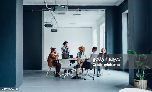 gruppo di uomini d'affari che hanno una riunione nella loro azienda moderna - five people foto e immagini stock