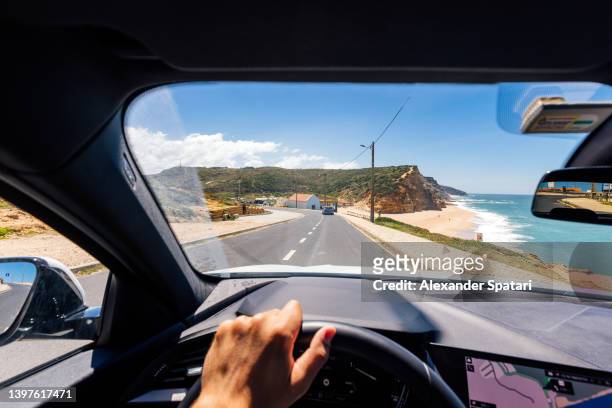 personal perspective point of view of a man driving along the atlantic coast in portugal - abfahrt stock-fotos und bilder