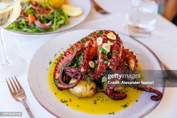 octopus served with potatoes in a restaurant, close-up - tentacule photos et images de collection