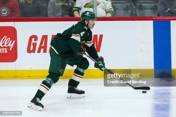 Jon Merrill of the Minnesota Wild skates with the puck against the St. Louis Blues in the third period in Game One of the First Round of the 2022...