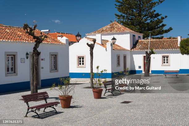 empty park benches in a square in the village of porto covo - a popular stop on the rota vicentina hiking trail, portugal - alentejo photos et images de collection