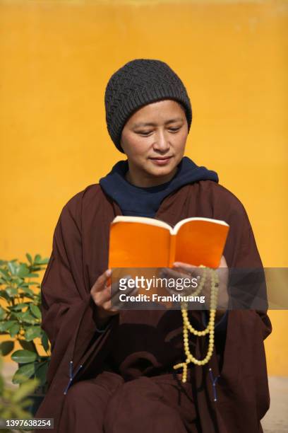a chinese nun reading a book in a temple - buddist nun stock pictures, royalty-free photos & images