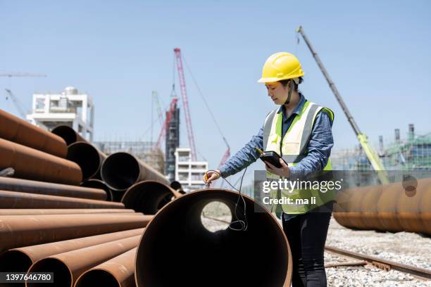 a female engineer uses a hardness tester to test the steel in a steel pipe. - metallurgical industry stock pictures, royalty-free photos & images