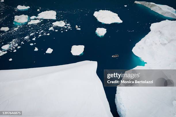 aerial view of iceberg and boat in arctic ocean - jakobshavn glacier stockfoto's en -beelden