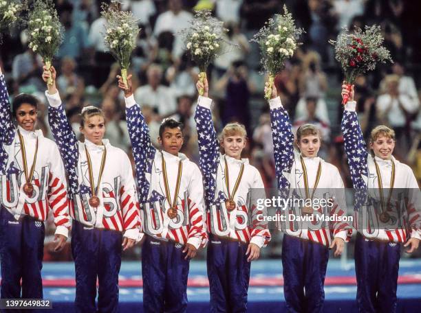 The team from the United States (L-R Betty Okino, Wendy Bruce, Dominque Dawes, Shannon Miller, Kerri Strug, and Kim Zmeskal wave to the crows after...