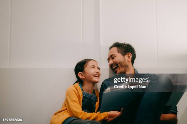 father and young daughter reading book together at home - kids reading stockfoto's en -beelden