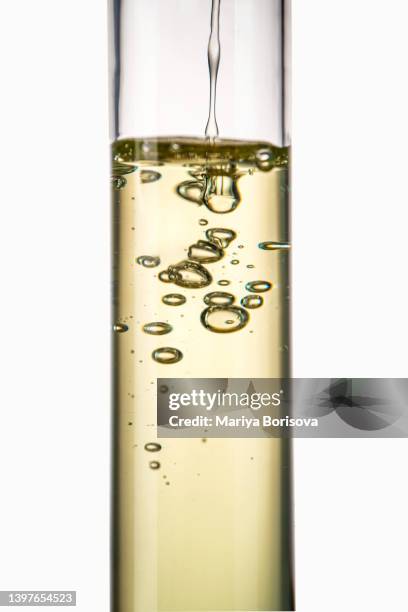 cosmetic oil is poured into test tube. - tube photos et images de collection