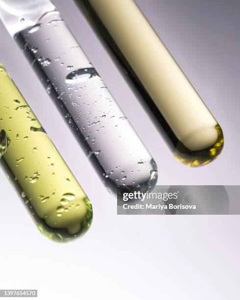 three test tubes with green gel, transparent cosmetic gel and oil. - antioxidants skin stock pictures, royalty-free photos & images