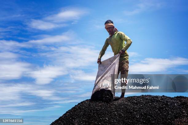 a worker is pouring coal in repository - bangladesh worker stock pictures, royalty-free photos & images