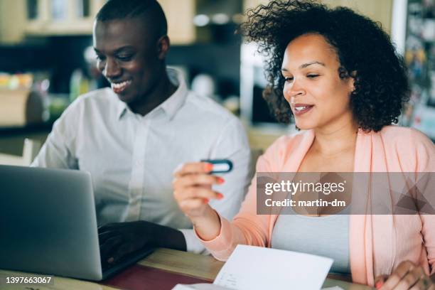 woman with her husband paying bills from home - token stock pictures, royalty-free photos & images