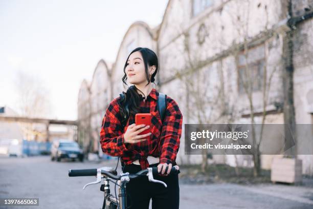japanische frau mit smartphone im freien - fahrradkurier frau stock-fotos und bilder